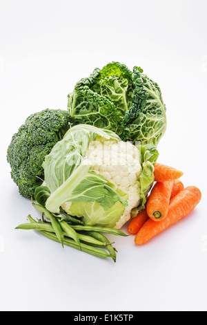 Una selezione di verdure su uno sfondo bianco questi comprendono broccoli Cavolfiori carote fagioli verdi e il cavolo. Foto Stock