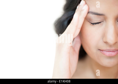 Modello rilasciato il ritratto di una donna di toccare la sua testa con gli occhi chiusi. Foto Stock