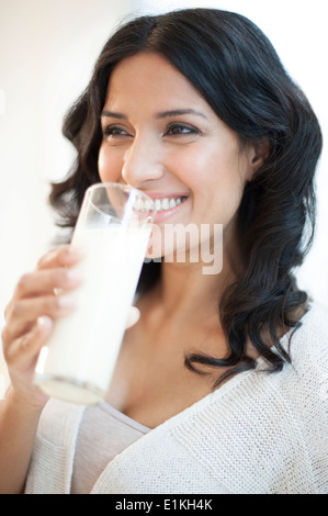 Modello rilasciato il ritratto di una donna di bere un bicchiere di latte. Foto Stock