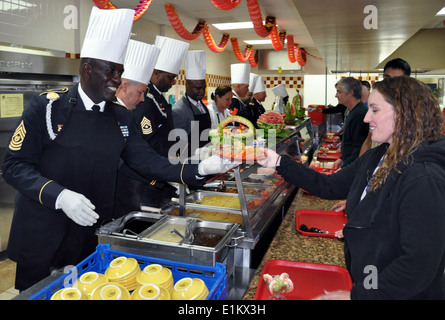 Stati Uniti Comando Esercito Sgt. Il Mag. Fahie Norriel, assegnato all'esercito attività di supporto, serve cena di ringraziamento a un membro di Joi Foto Stock