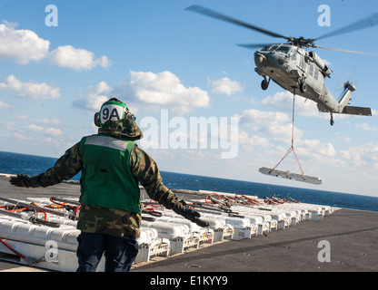 Stati Uniti Aviazione Navale meccanico strutturale di terza classe Anthony Scott segnali ad un MH-60S Seahawk elicottero assegnato all'ELICOTTERO S Foto Stock