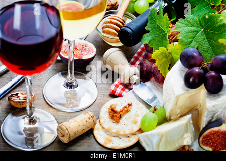 Vino, uva e formaggio su sfondo di legno Foto Stock