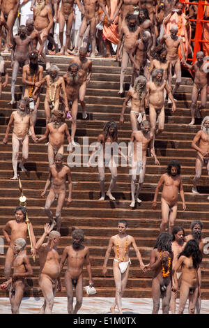 Naga sadhus passeggiando per le fasi di Har-ki-Pauri ghat a fare un tuffo nel fiume Gange in occasione di 'Somvati Amavasya', Foto Stock