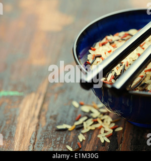 Riso selvatico in vaso in ceramica su sfondo di legno Foto Stock