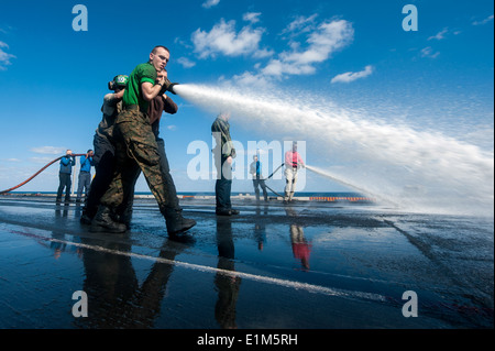 Stati Uniti Marinai e Marines il tubo flessibile verso il basso il ponte di volo della portaerei USS Harry Truman (CVN 75) nel Golfo di Oman Jan Foto Stock