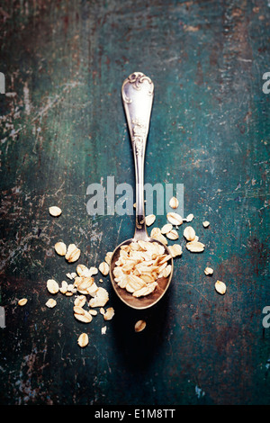 Avena in un cucchiaio di metallo sul tavolo di legno Foto Stock