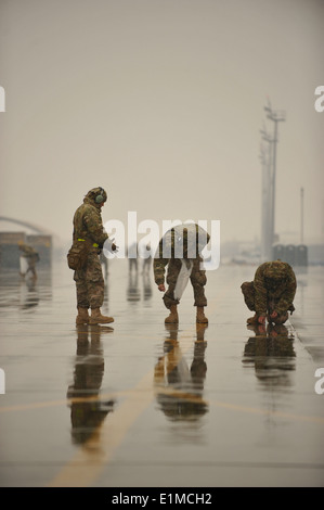 Stati Uniti Avieri con il 455th Expeditionary Manutenzione aeromobili squadrone look per i detriti in corrispondenza di Bagram Airfield, Afghanistan, 6 febbraio Foto Stock