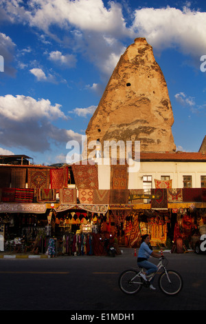 La Turchia; Cappadocia; Anatolia; di Göreme; tramonto; persone; ragazza; Bicicletta; Shop; presente; Sun; House; moquette Foto Stock