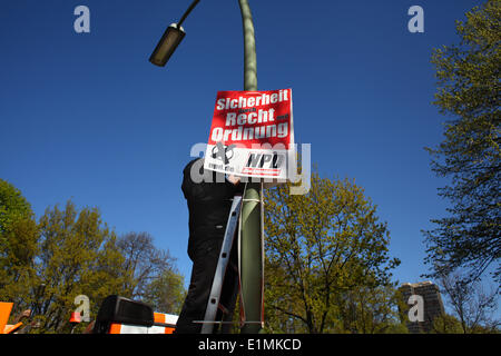 Un uomo dall'Europa Orientale appendere manifesti elettorali per il radicale tedesco partito rightwingers NPD (tedesco Nationaldemocratic Paty) prima delle elezioni europee il 16 aprile 2014. Foto: Wolfram Steinberg dpa Foto Stock