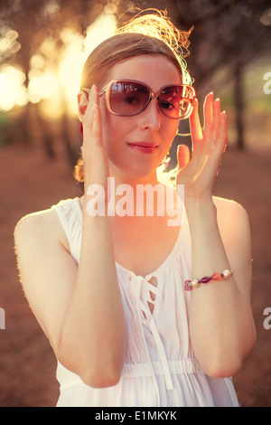 Giovane donna ritratto al tramonto sullo sfondo. Foto Stock