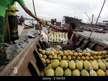 Yangon, Myanmar. Il 6 giugno, 2014. Un uomo vende manghi sulla sua piccola barca presso la banca di fiume Yangon di Yangon, Myanmar, Giugno 6, 2014. © U Aung/Xinhua/Alamy Live News Foto Stock