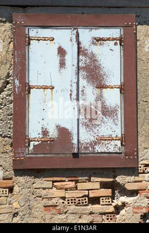 Vecchie persiane chiuse su un abbandonato edificio greco Foto Stock