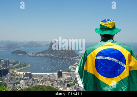 Patriottici fan brasiliano in piedi avvolti in bandiera a Sugarloaf Mountain vista Botafogo Rio de Janeiro in Brasile Foto Stock