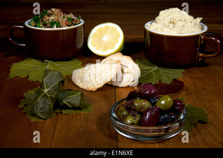 In Medio Oriente la diffusione di antipasti tra cui tabulé, hummas, dolma, fatayees e speziato olive su una tavola di legno Foto Stock