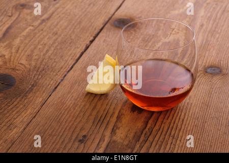 Il cognac di lusso in vetro decorativo su legno con il limone Foto Stock