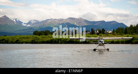 Un piano bush esegue il decollo in Alaska con Chugach Mountains in background Foto Stock