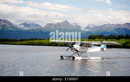 Un piano bush esegue il decollo in Alaska con Chugach Mountains in background Foto Stock