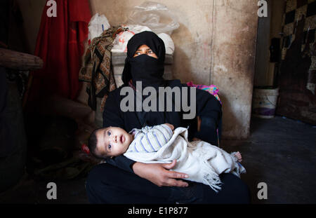 La striscia di Gaza City, nella Striscia di Gaza. 8 Giugno, 2014. Madre palestinese HEMIDAN OM, 33, tenendo il suo quattro-mese-vecchio RAKAN bambino dentro la sua tenda dove essi hanno vissuto negli ultimi due anni dopo che il governo li evacuati da un ex poliziotto composto. La famiglia lotte mentre vive al di sotto della soglia di povertà Al Zaitoun vicinato di Gaza City. © Eman Mohammed/ZUMAPRESS.com/Alamy Live News Foto Stock
