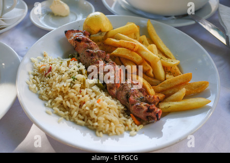 Souvlaki servito con riso e patate fritte in Atene Foto Stock