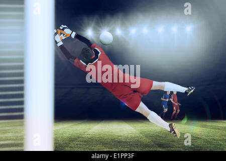 Immagine composita di portiere in rosso il salto Foto Stock