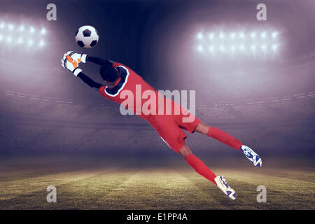 Immagine composita di portiere in rosso effettuare un salvataggio Foto Stock