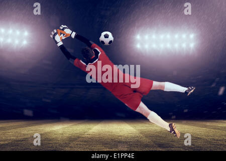 Immagine composita di portiere in rosso il salto Foto Stock