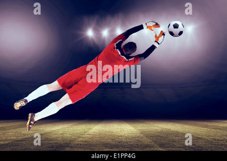 Immagine composita di portiere in rosso il salto Foto Stock