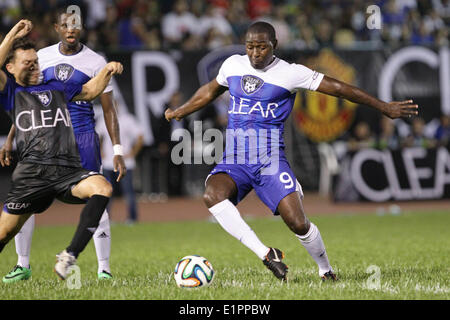 Manila, Filippine. Il 7 giugno, 2014. Makati, Filippine - Ex Manchester United player Andy Cole (R) tussles per la palla durante una mostra gioco contro amatuer locale e i giocatori professionisti in Makati, ad est di Manila il 7 giugno 2014. © Mark Cristino/NurPhoto/ZUMAPRESS.com/Alamy Live News Foto Stock