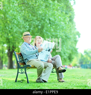 Uomo maturo e la donna la lettura di notizie all'esterno Foto Stock