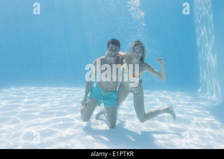 Carino Coppia sorridente in telecamera subacquea in piscina Foto Stock