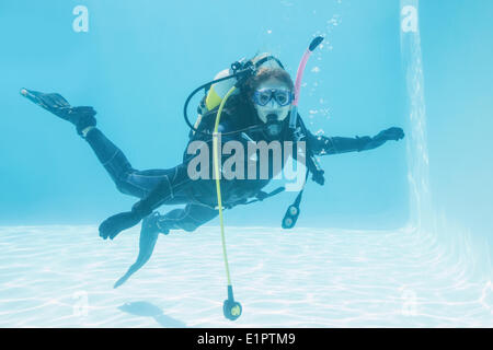 Donna sulla formazione di scuba sommerso in piscina Foto Stock