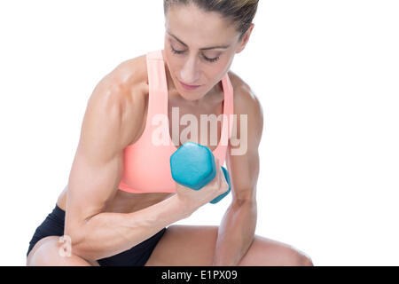 Donna forte facendo bicipite curl con manubrio blu Foto Stock