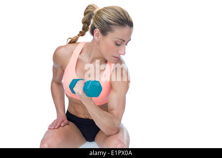 Donna forte facendo bicipite curl con manubrio blu Foto Stock