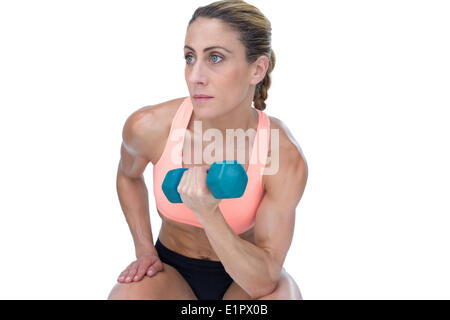 Donna forte facendo bicipite curl con manubrio blu Foto Stock