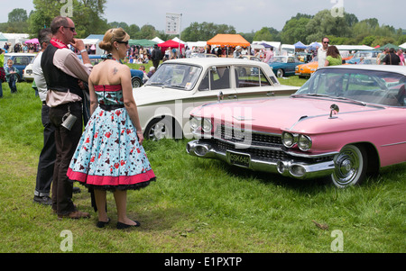 La gente vestita fino ad un nostalgico e vintage visualizza guardando una rosa Cadillac. Inghilterra Foto Stock