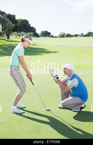 L'uomo coaching il suo partner sul putting green Foto Stock