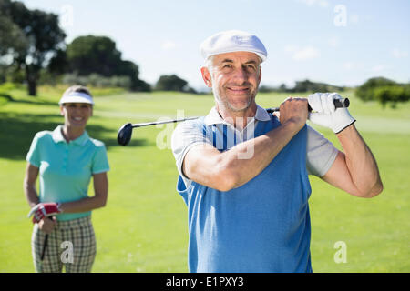 Felice golfista off di rinvio con il partner dietro di lui Foto Stock