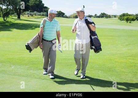 Il Golfer amici passeggiate a piedi e in chat Foto Stock