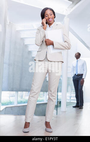 Agente immobiliare a parlare al telefono con il compratore in background Foto Stock
