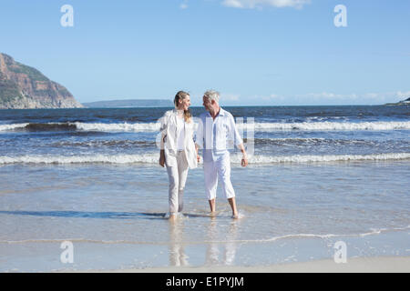 Coppia felice passeggiando a piedi nudi sulla spiaggia Foto Stock
