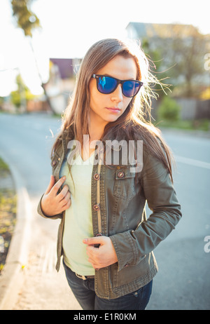 Close up lifestyle ritratto di pretty moda giovane brunette in occhiali da sole su il sole al tramonto Foto Stock