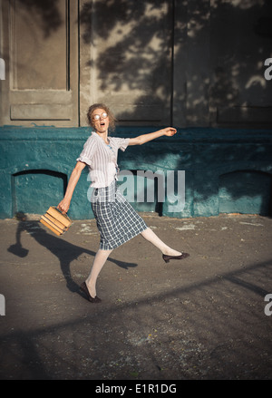 Funny Girl studente con libri in bicchieri e un Vintage dress all'aperto Foto Stock