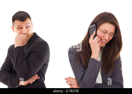 Sospettoso uomo che guarda la sua donna che parla sorridente al telefono Foto Stock