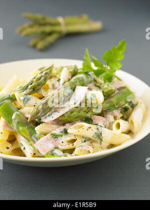 Penne in salsa alla panna con asparagi e prosciutto Foto Stock