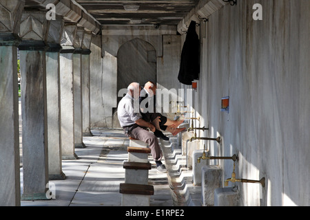 Uomini musulmani lavando loro i piedi, prima della preghiera Foto Stock