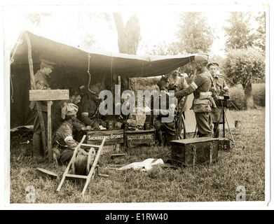 Questa fotografia raffigura una stazione di segnalazione della brigata Dehra Dun, che mostra la sezione del quartier generale al lavoro durante la prima guerra mondiale a St Floris, in Francia. L'immagine include varie unità dell'esercito indiano come il 15th Sikh, il 18th Lancers e i Gurkha, insieme a scene di personale militare, operazioni di segnale e cure mediche sul campo. Foto Stock