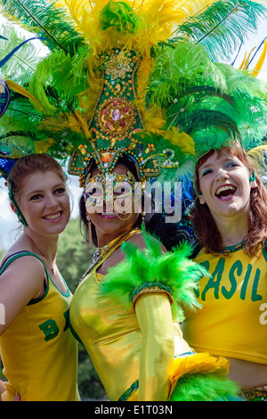 Tre donne vestite nei tradizionali costumi brasiliano, prendendo parte al West End Street Festival e Mardi Gras, Glasgow Foto Stock