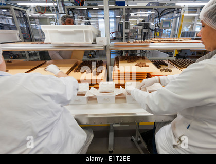 Lavoratori presso lo Swiss la fabbrica di cioccolato di Lindt & Spruengli in Zurigo / Kilchberg sono operazioni di cernita e di imballaggio di cioccolatini. Foto Stock