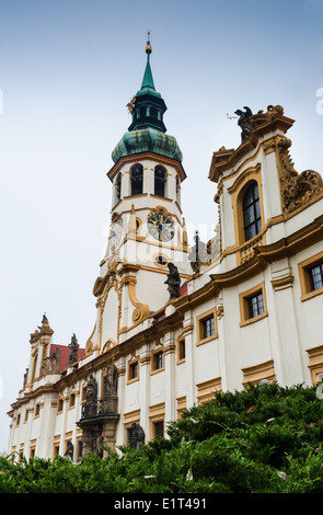 Loreta Santuario a Praga, con le statue di santi sull'ingresso principale e con torre campanaria barocca Foto Stock