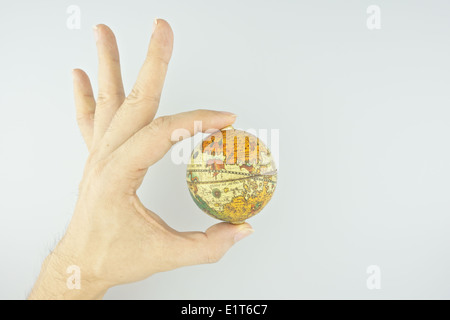 Mano di uomo rendere il segnale di ok con capovolta del globo isolato su sfondo bianco. Foto Stock